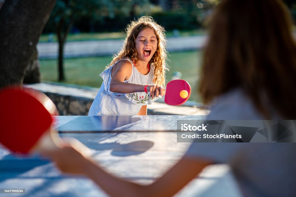 happy looking girl playing table tennis
